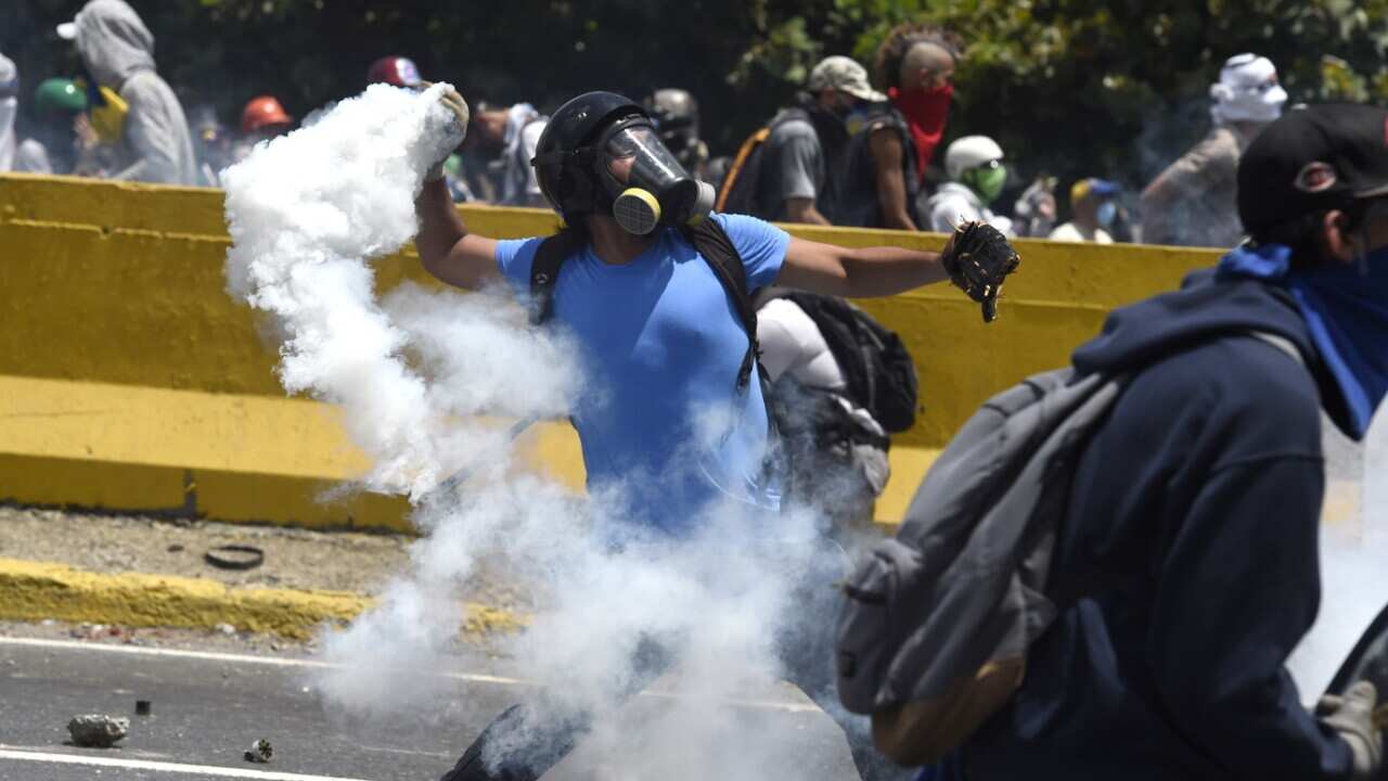 Opposition activists clash with riot police during a protest march in Caracas on April 26, 2017.