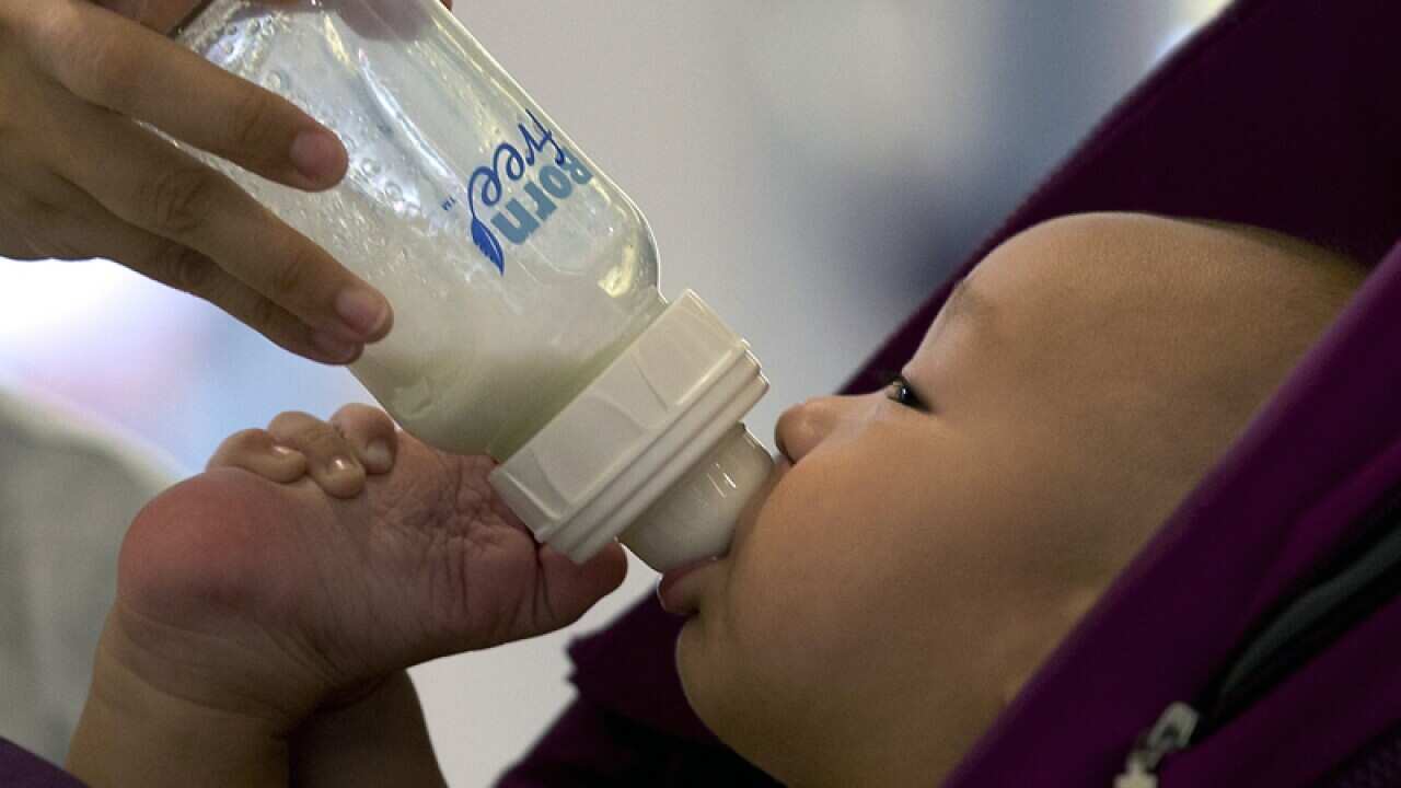 A baby is fed milk from a bottle