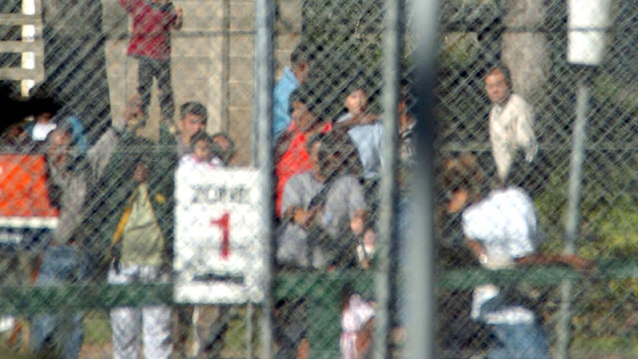 A file photo of a young child behind the fences of a Detention Centre
