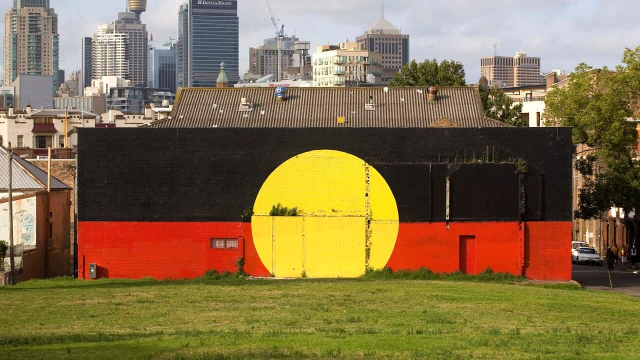 An Aboriginal flag mural is pictured in front of the Sydney skyline in Redfern, Sydney, Australia, Monday, Jan. 28, 2008.