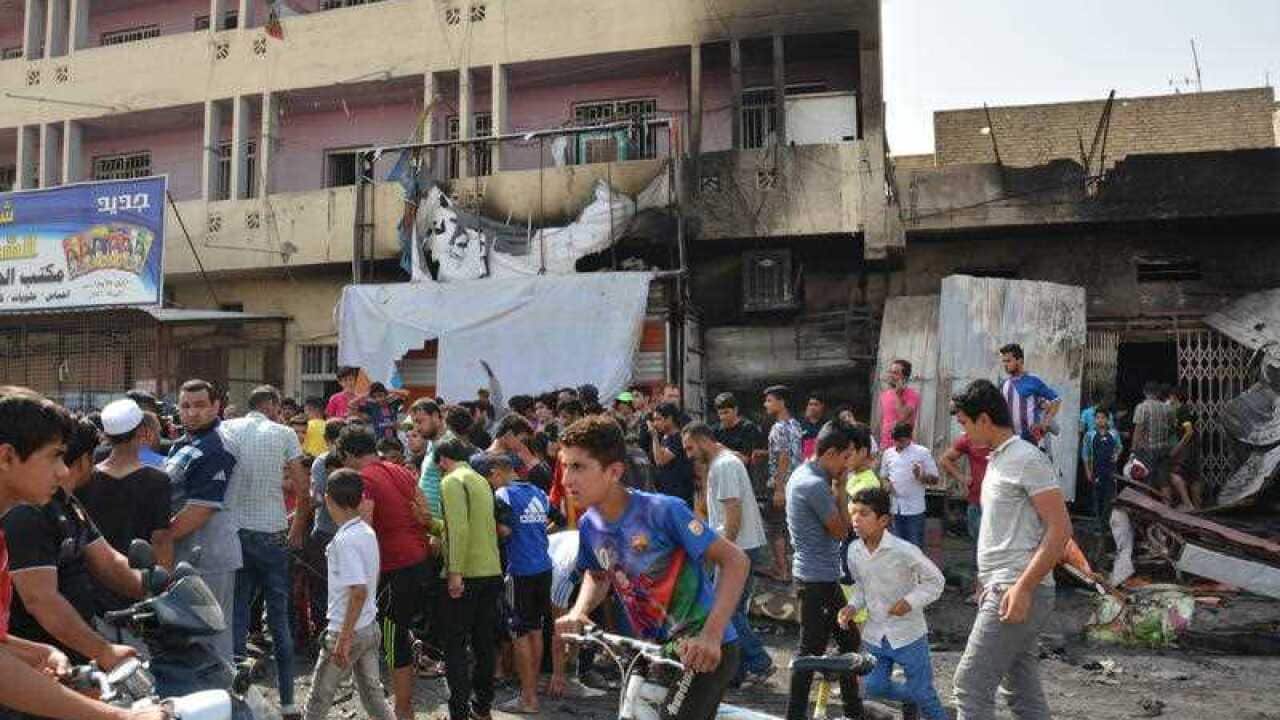Iraqis look at the damage following a car bombing that killed at least 52 people at Uraiba marketplace in Sadr City, a Shiite area in northeastern Baghdad