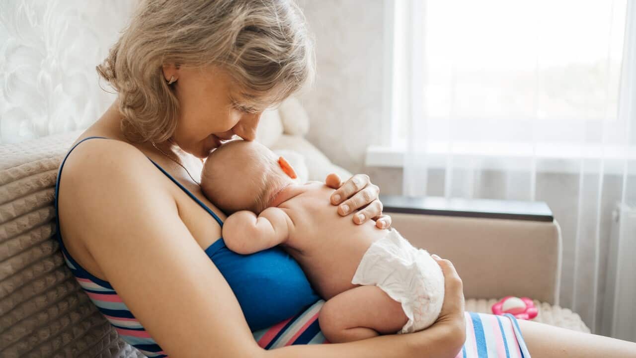 newborn baby in mother's arms at home