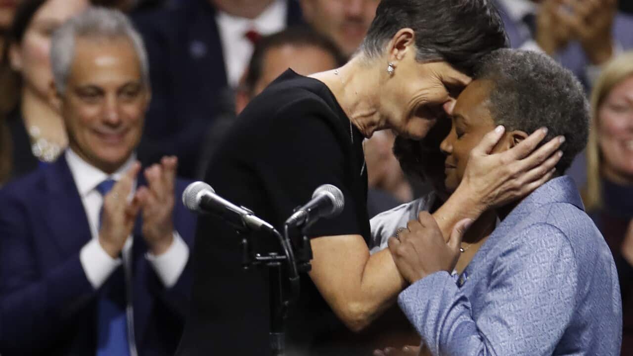 Mayor of Chicago Lori Lightfoot, right, embraces her spouse Amy Eshleman as outgoing Mayor Rahm Emanuel look on during her inauguration ceremony.
