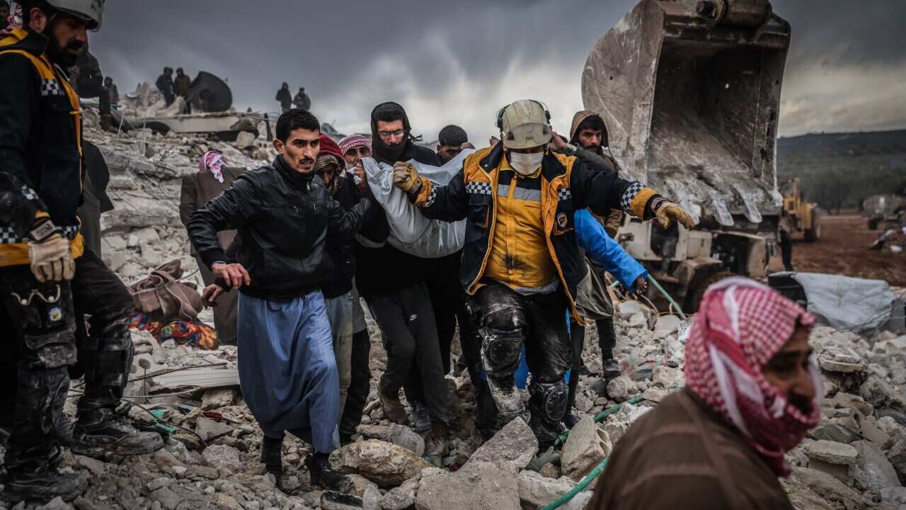 Rescuers carrying a survivor through the rubble