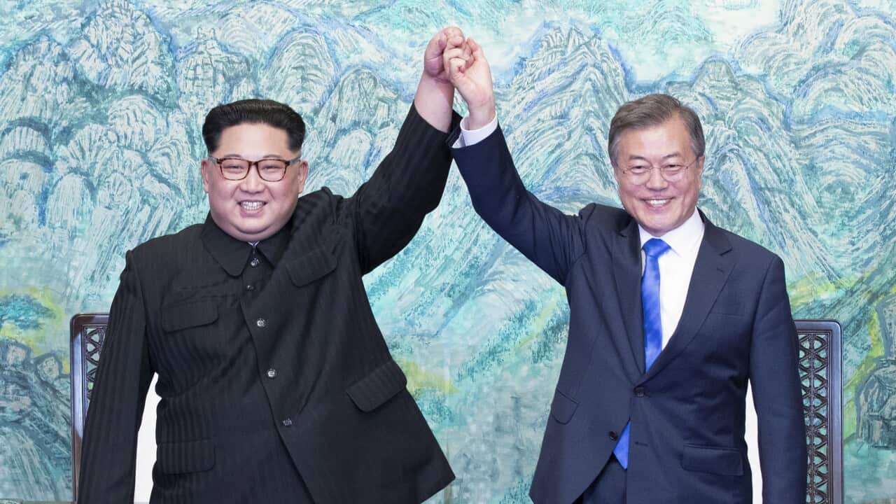 North Korean leader Kim Jong-Un and South Korean President Moon Jae-In join hands after signing a document at the Joint Security Area on the DMZ.