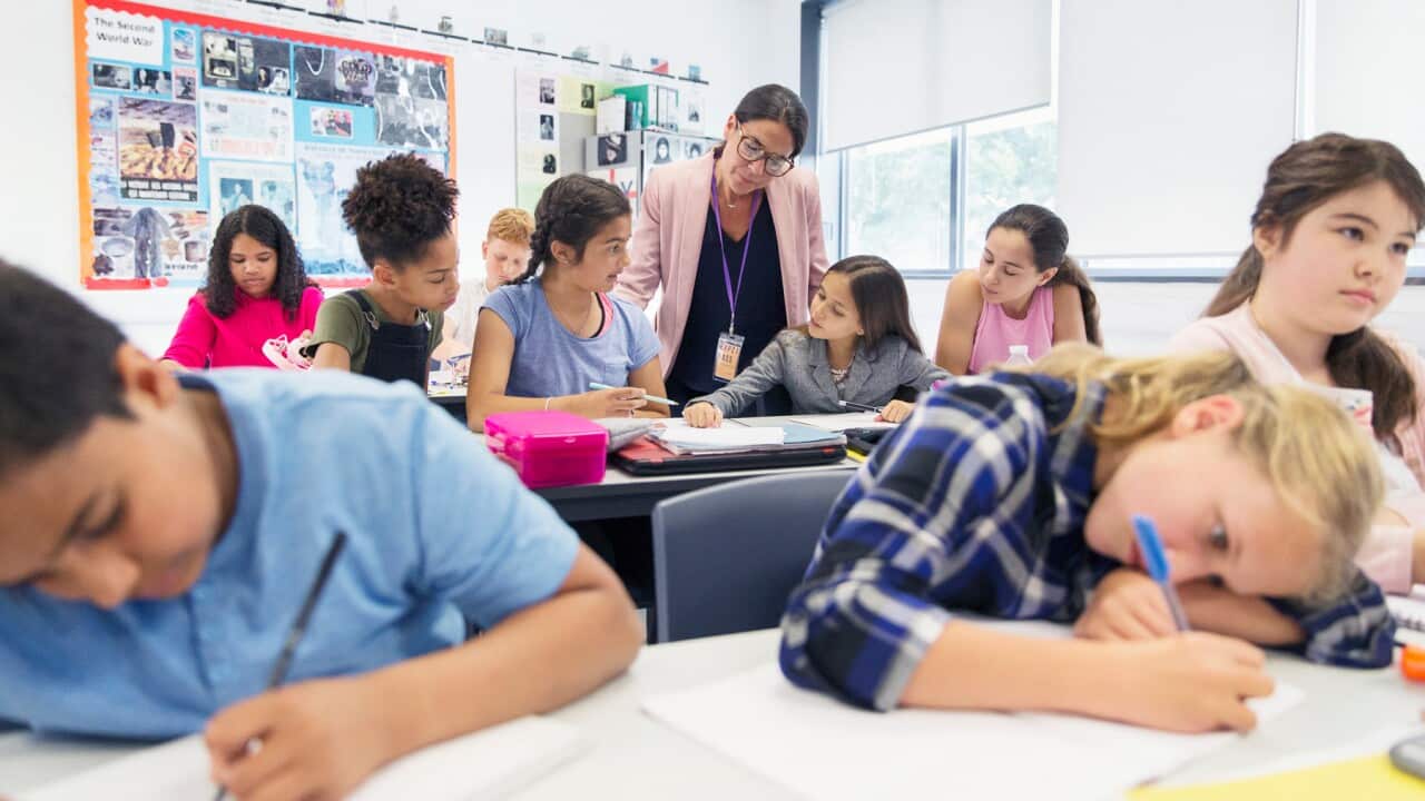 A teacher in a classroom full of children (Getty)