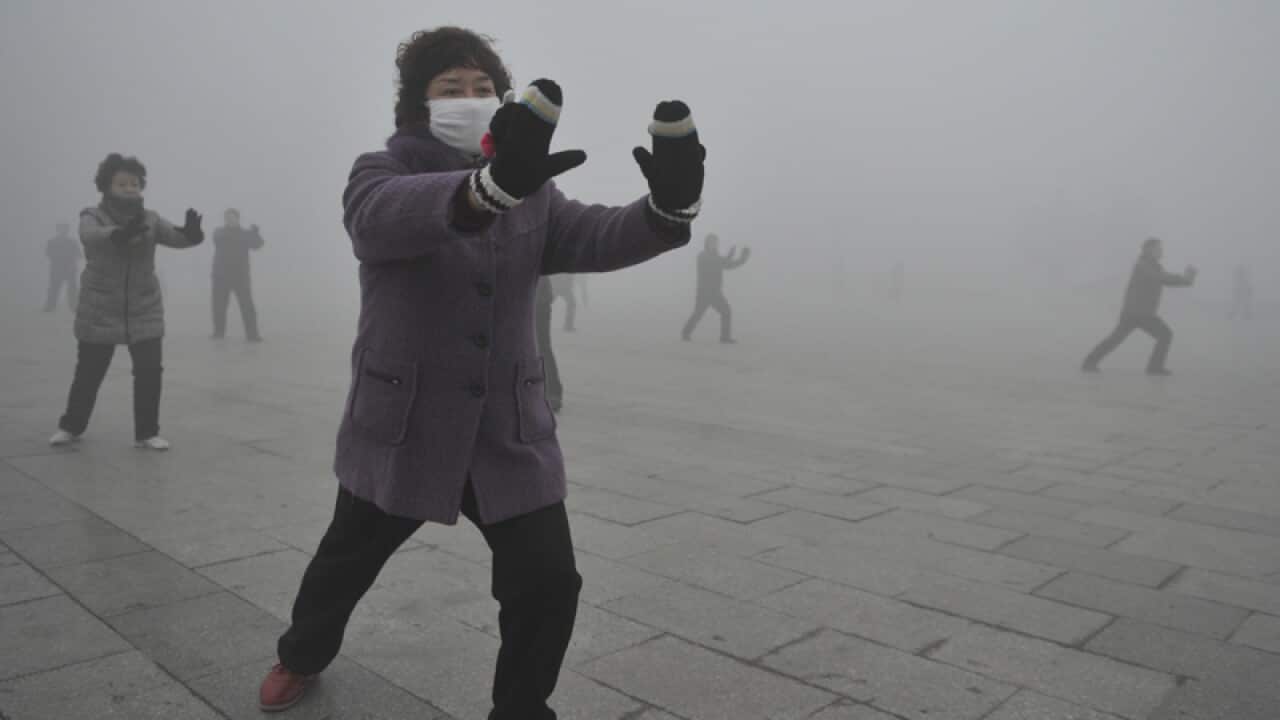 Retirees play Taichi on a hazy day in Fuyang city, China