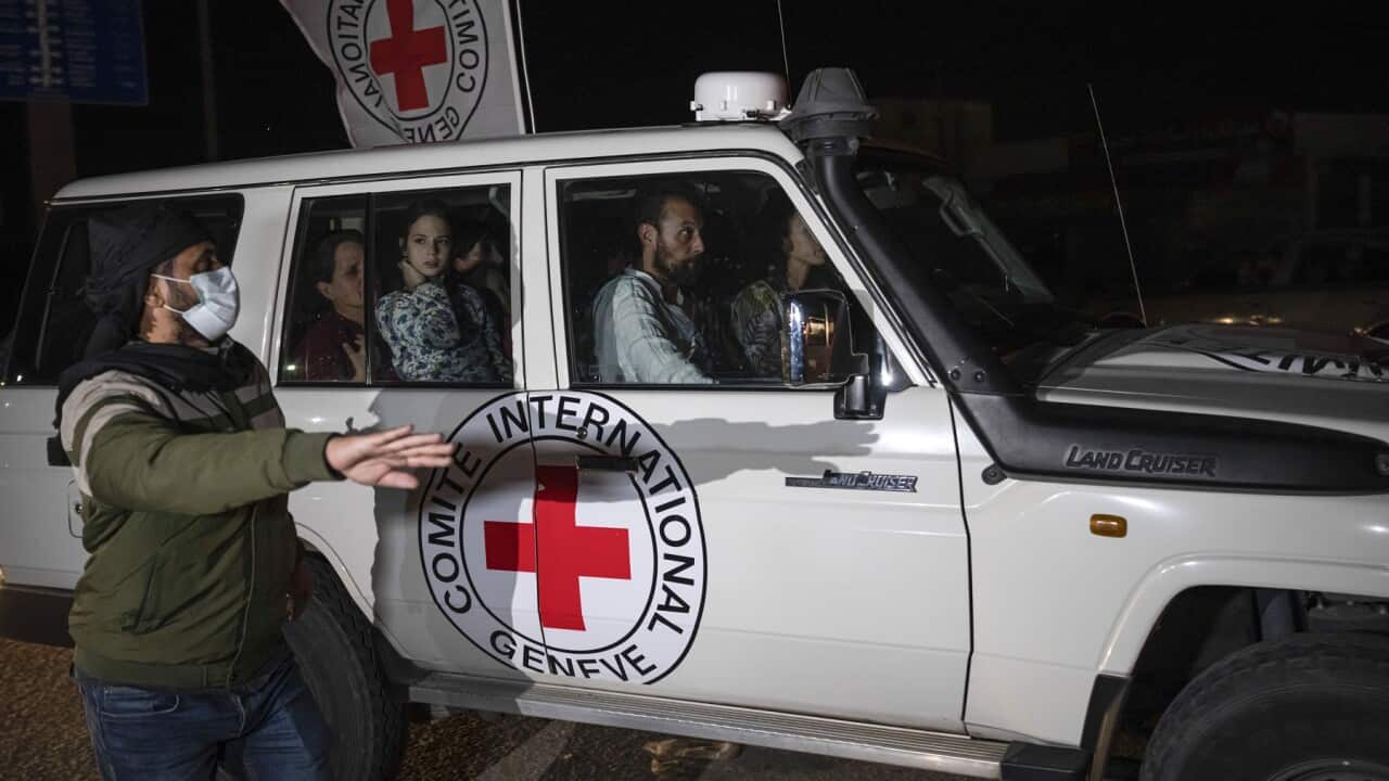 A Red Cross vehicle carrying Israeli hostages drives by at the Gaza Strip crossing into Egypt in Rafah on Saturday.