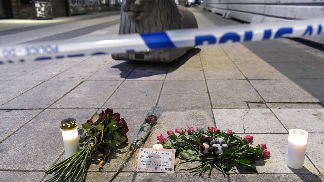 Candles and flowers are placed near the site where a beer truck crashed into a department store in central Stockholm, Sweden