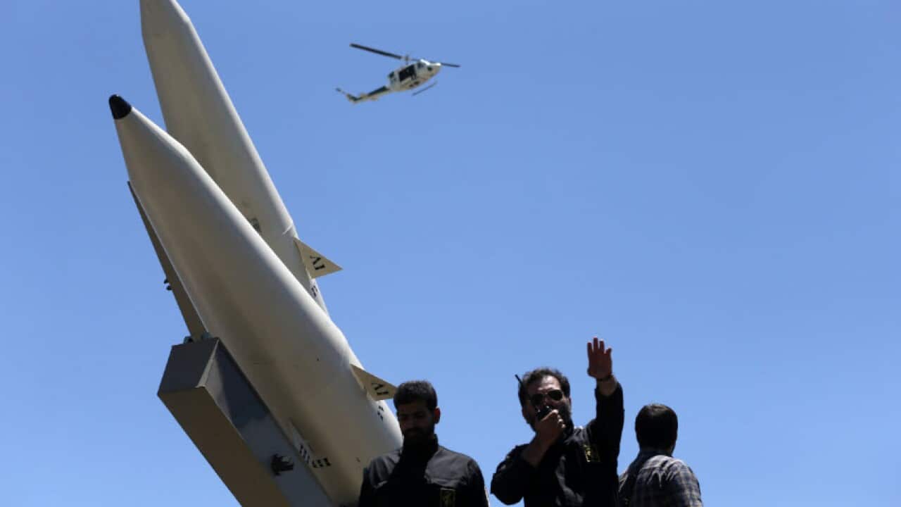 A member of Iranian Revolutionary Guard speaks on his walkie talkie while Zolfaghar surface-to-surface ballistic missiles are displayed in an annual pro-Palestinian rally marking Al-Quds