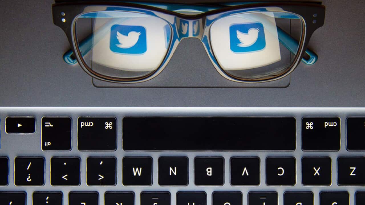 the logo of Twitter reflected in a pair of glasses