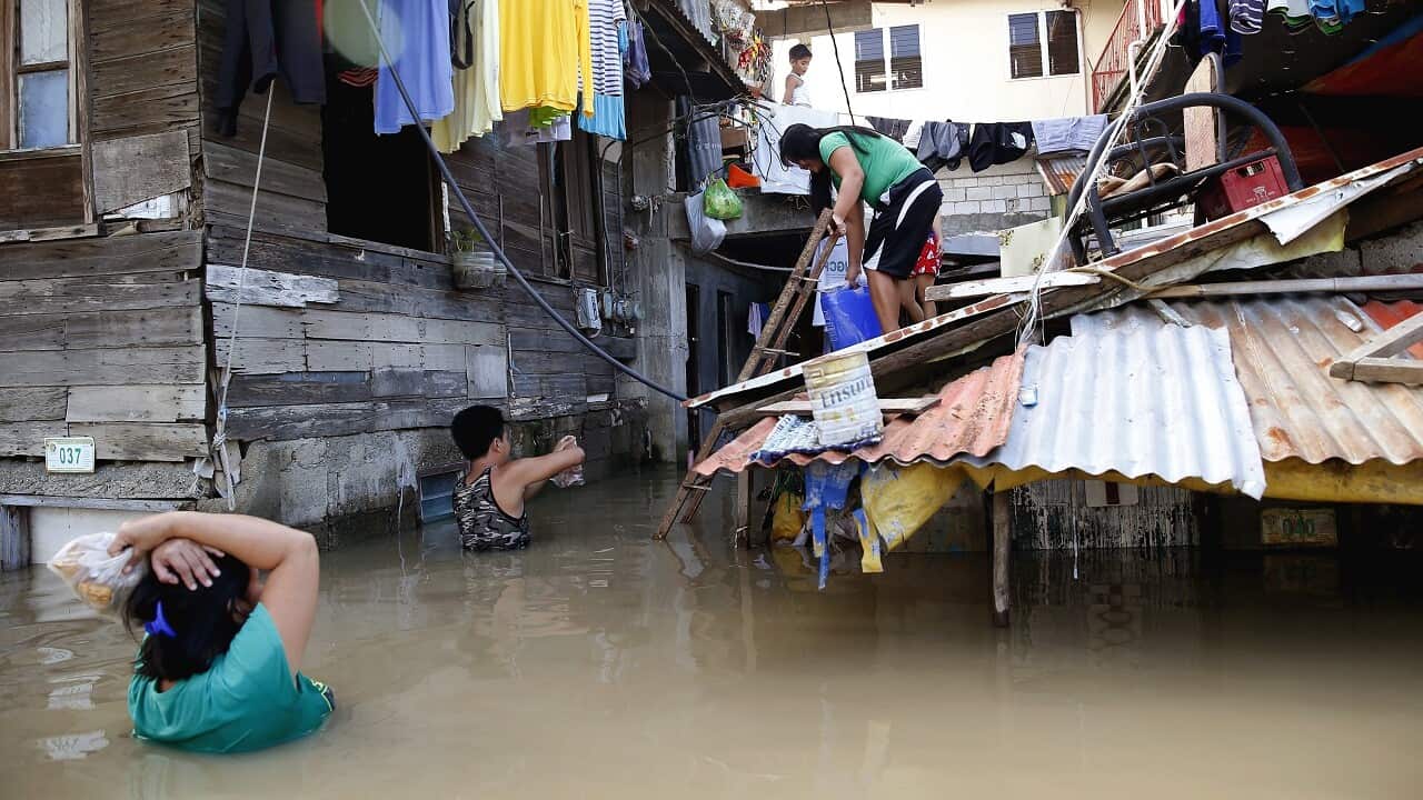 People wade through floodwaters in Calumpit township, north of Manila.