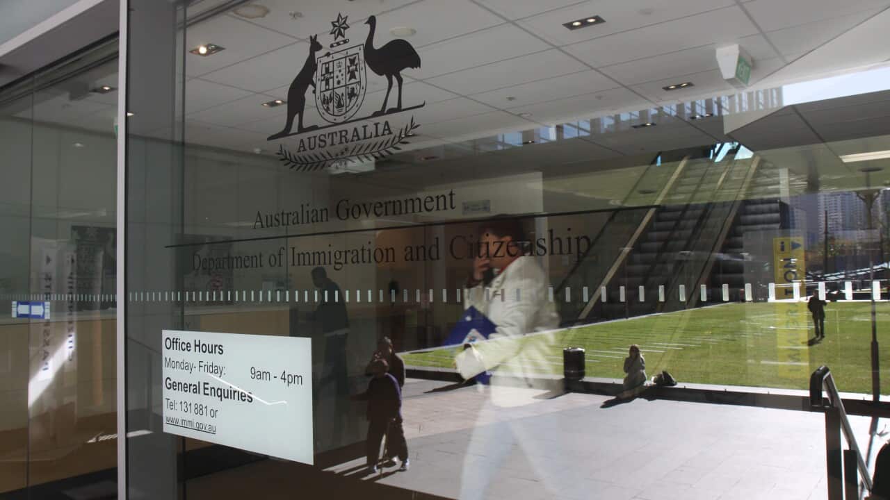 A man walks behind a glass door.