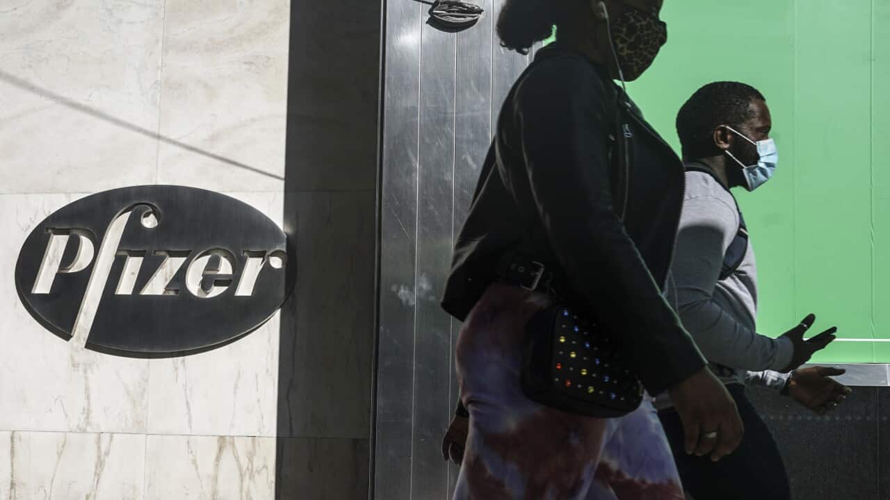 Pedestrians walk past Pfizer world headquarters, Monday 9 November, 2020, in New York.