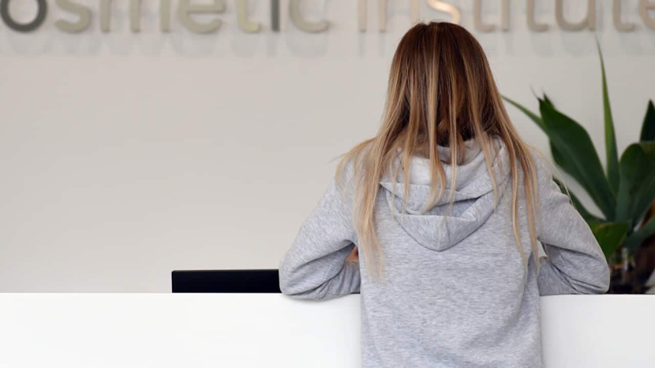 A woman waits at the Cosmetic Institute in Sydney