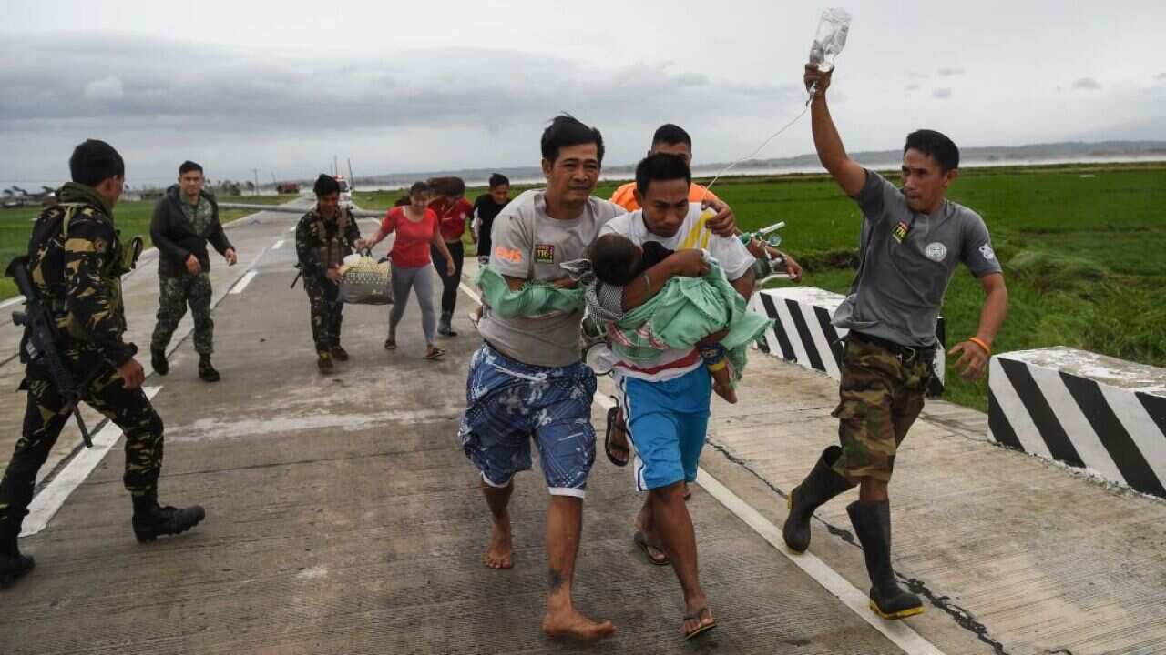 Philippine soldiers assist a family carrying their sick child