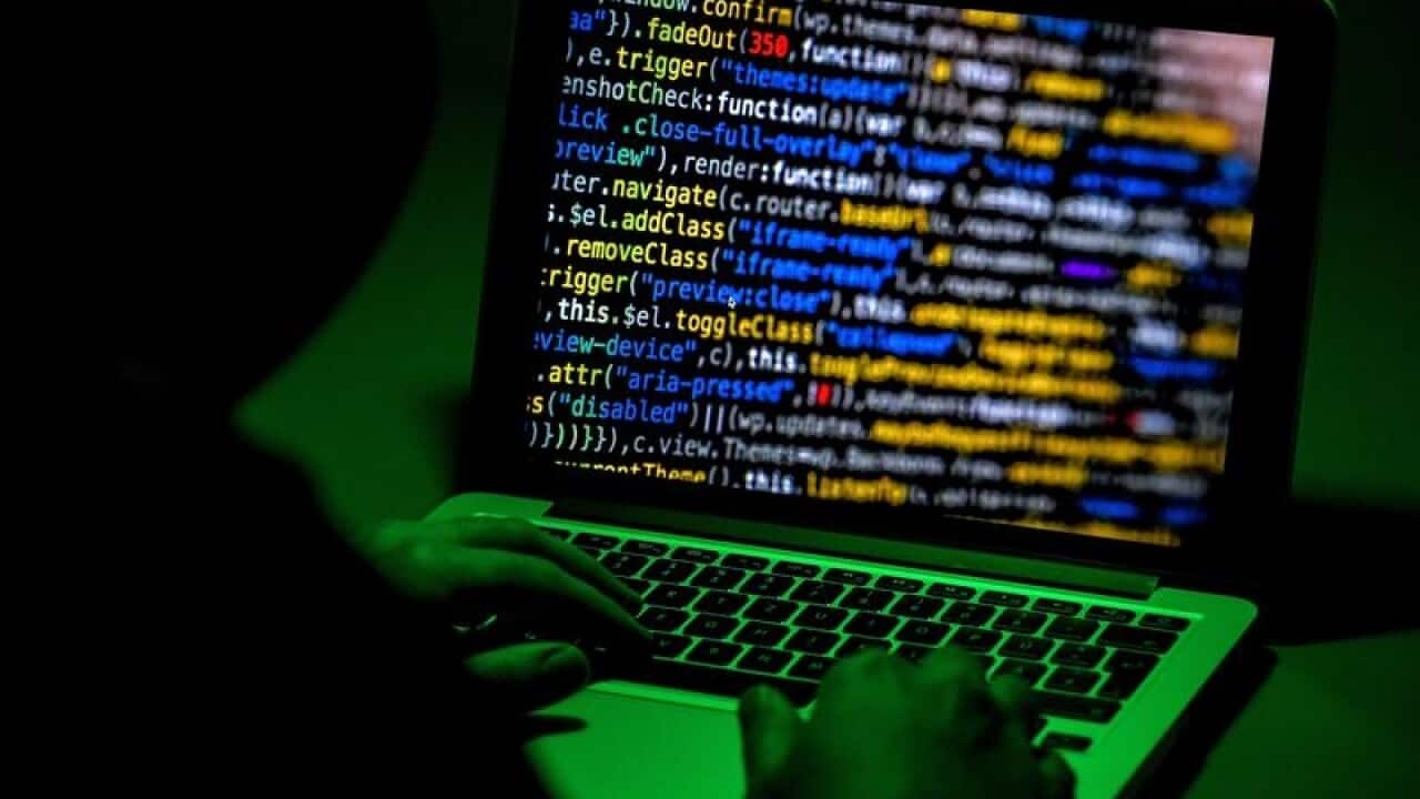 A person sits in front of a computer screen