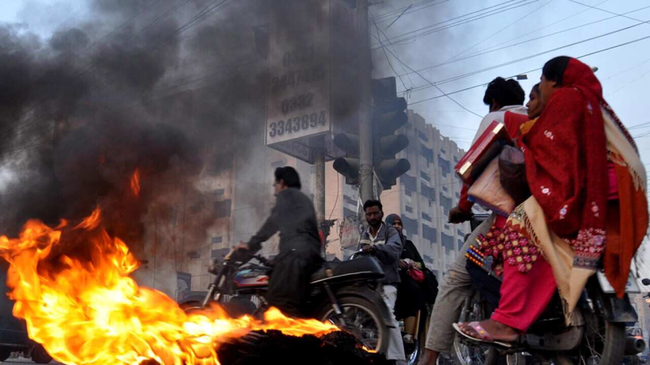 Pakistanis burn tyres during a protest against the suicide bombing