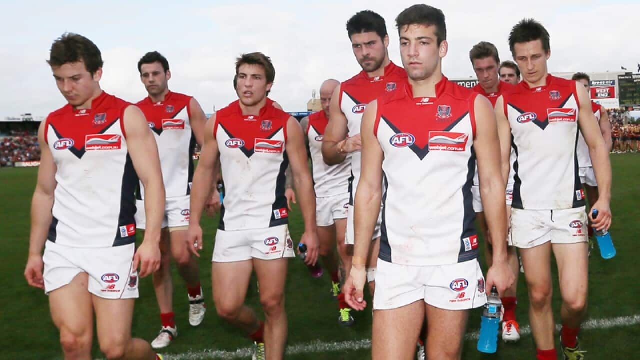 Melbourne Demons players leave the field
