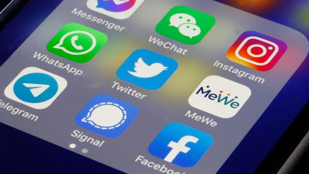 The logos of social media applications, Messenger, WeChat, Instagram, WhatsApp, Twitter, MeWe, Telegram, Signal and Facebook are displayed on an iPhone.