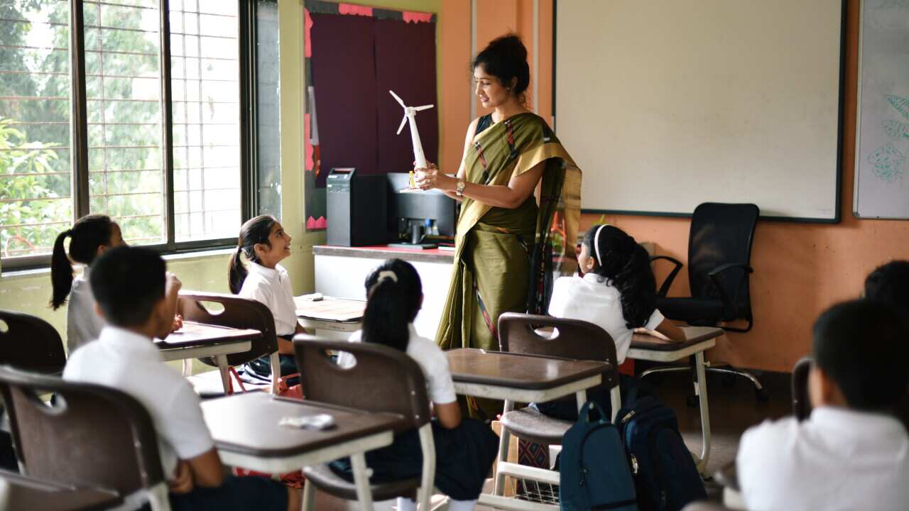 Teacher teaching concepts of windmill in the classroom to students