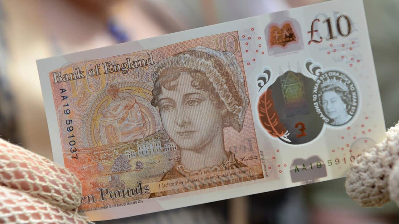 People in period costume display the new Â£10 note featuring Jane Austen, which marks the 200th anniversary of Austen's death