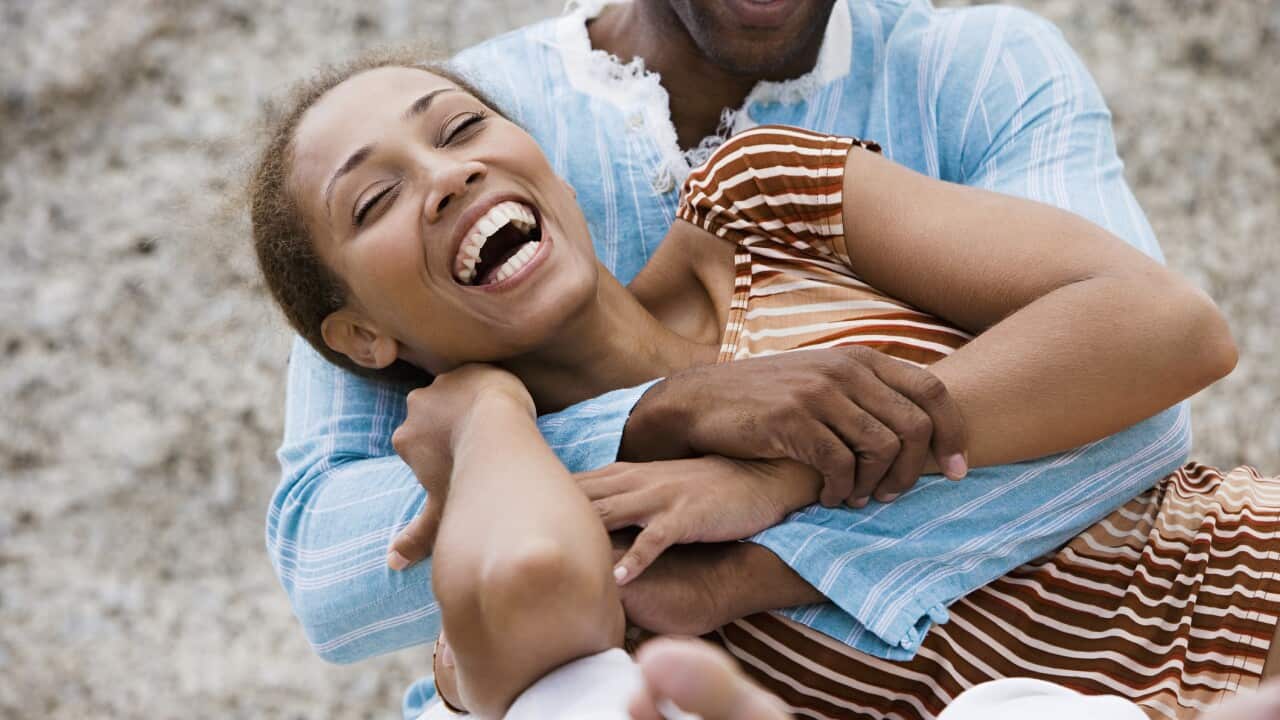 Couple laughing, man embracing woman, close-up