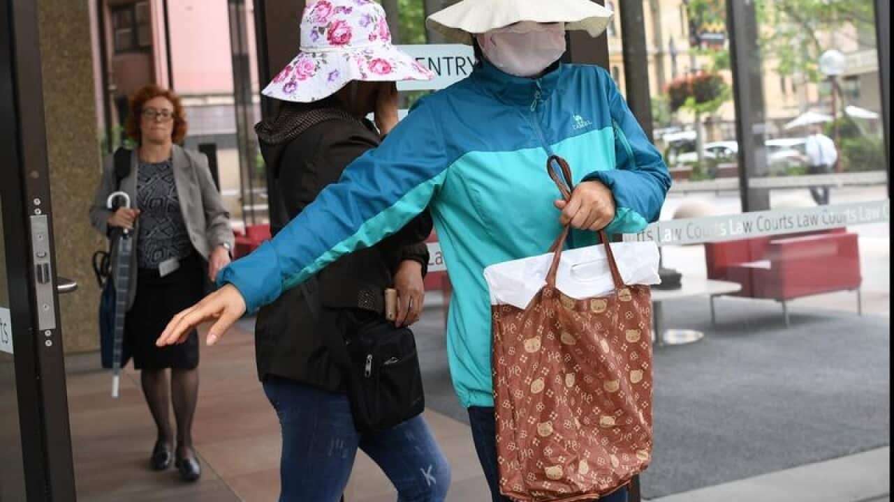 Family members of Yueqiong Fu cover their faces