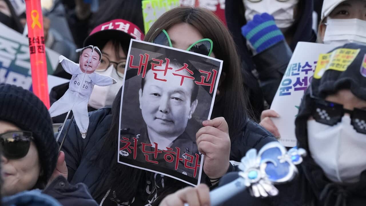 A protester holds images of impeached South Korean President Yoon Suk Yeol during a rally demanding immediate indictment of Yoon in Seoul, South Korea, Saturday, Jan. 25, 2025.