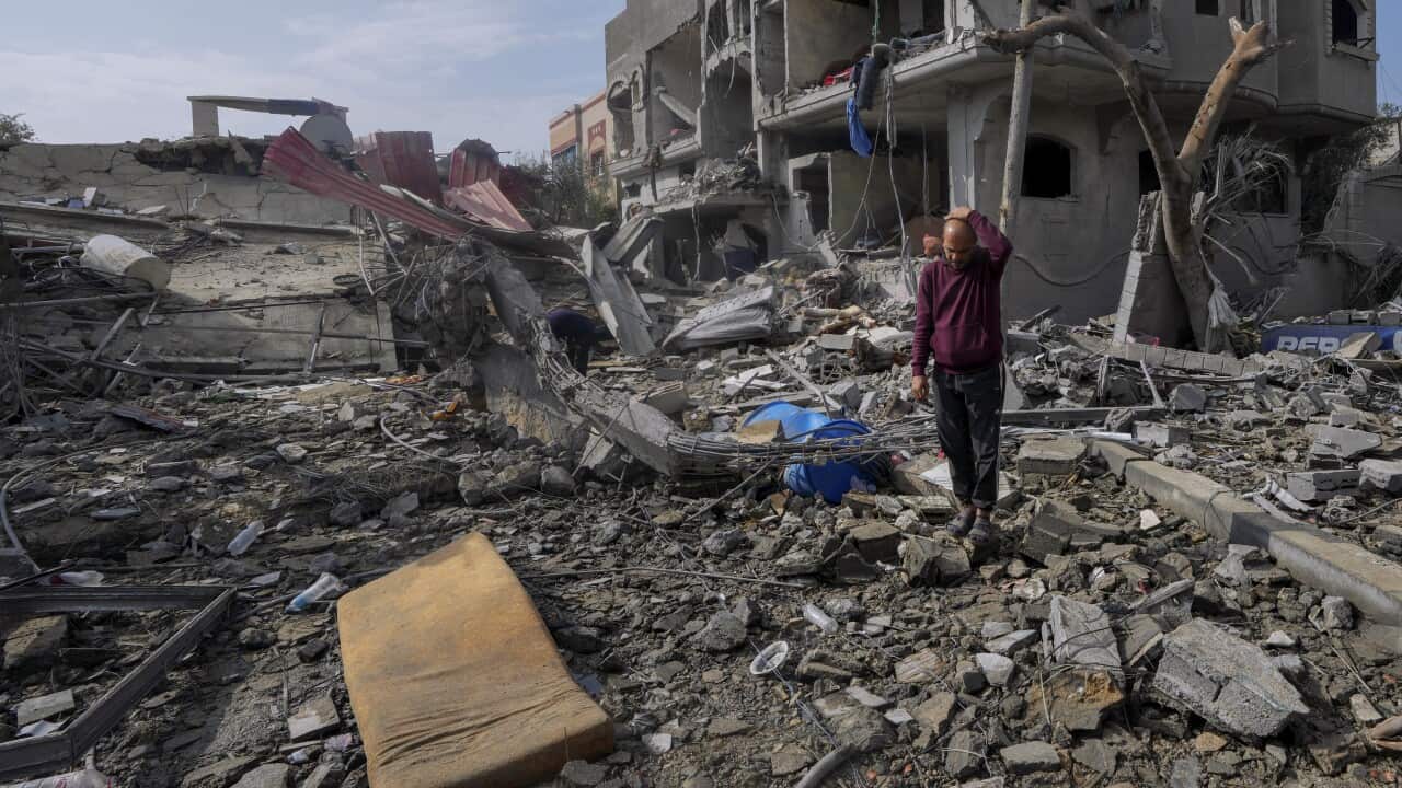 A man standing in the rubble of destroyed buildings