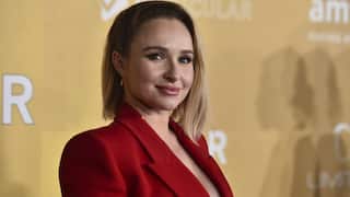 Hayden Panettiere, standing in front of a yellow background.