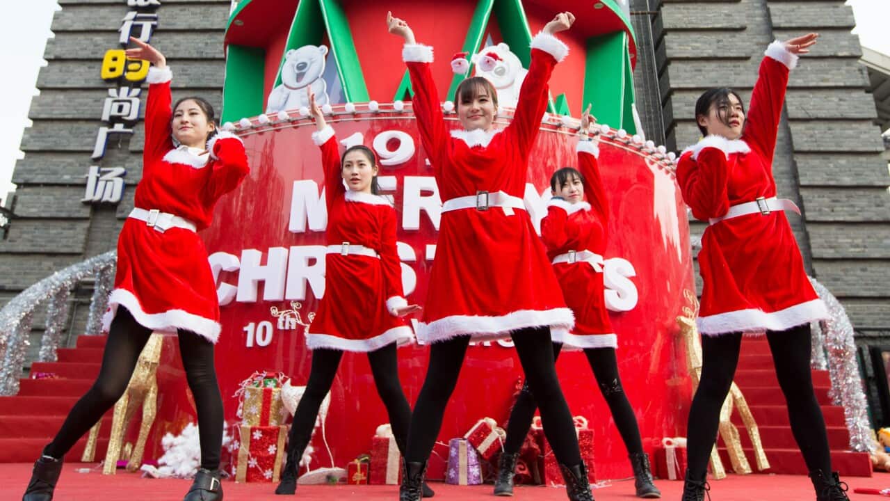 Young girls dressed in Santa Claus costumes perform during a street dance show to celebrate Christmas in Nanjing city, east China's Jiangsu province (AAP)