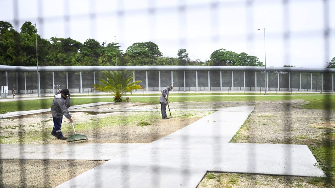 Staff work near the perimeter fence during a tour of the North West Point Detention Centre on Christmas Island