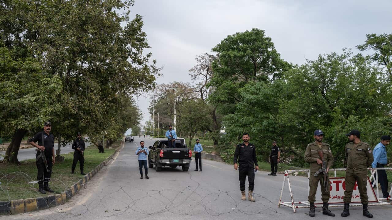 Soldiers in uniform holding weapons at a road checkpoint in Pakistan