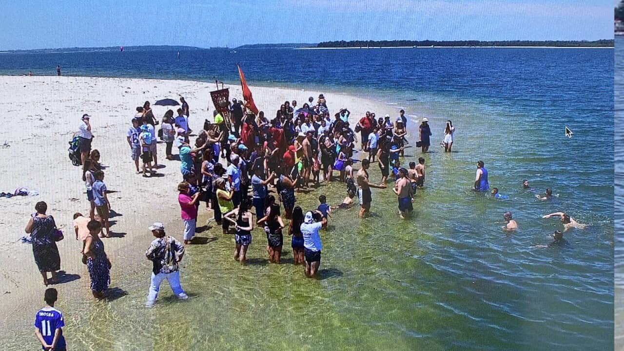Epiphany traditions in Sydney - Macedonian priest, rev.Naum Despotovski throws a cross into the ocean before divers jump to catch the cross (archive)