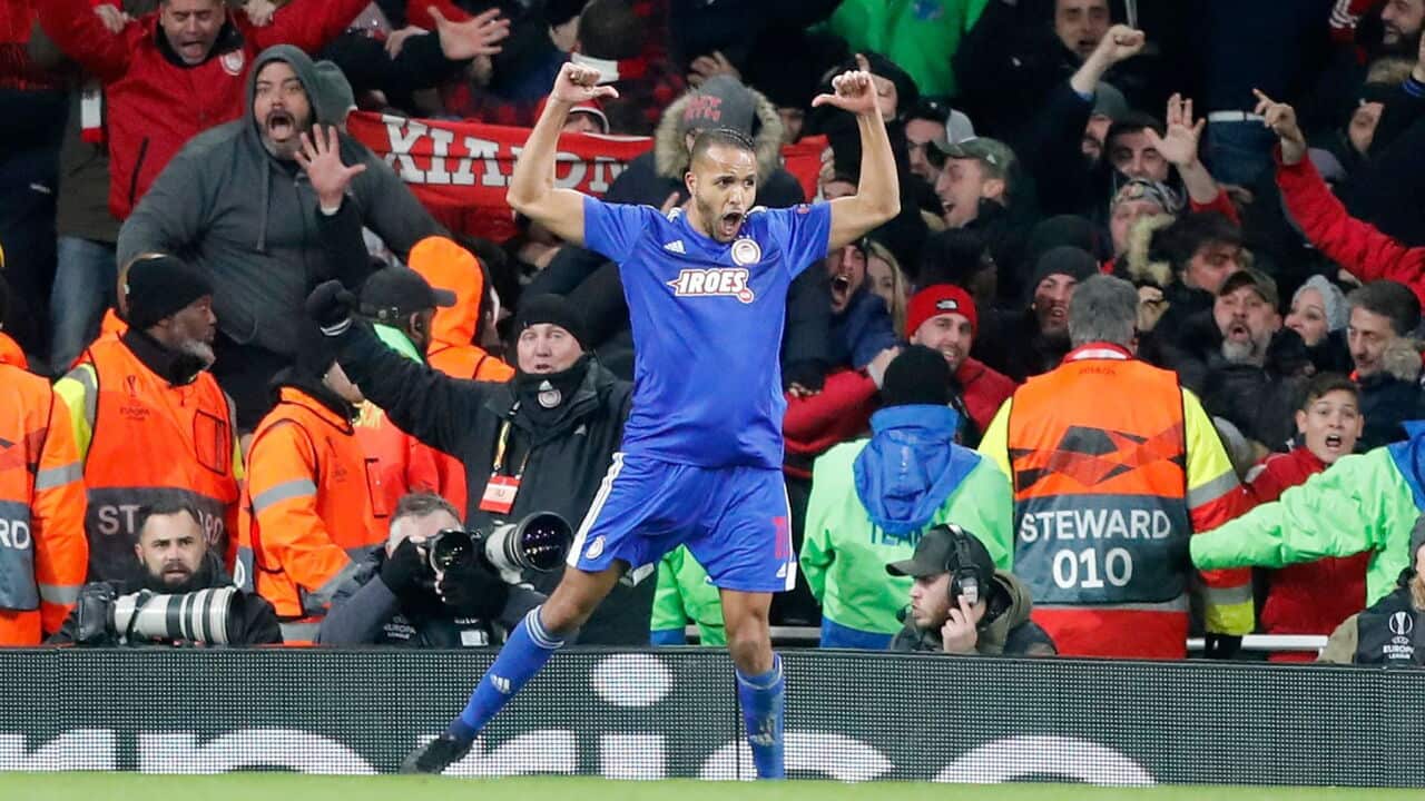 Olympiakos' Youssef El-Arabi, left, celebrates scoring during the Europa League round of 32, second leg, soccer match between Arsenal and Olympiakos.