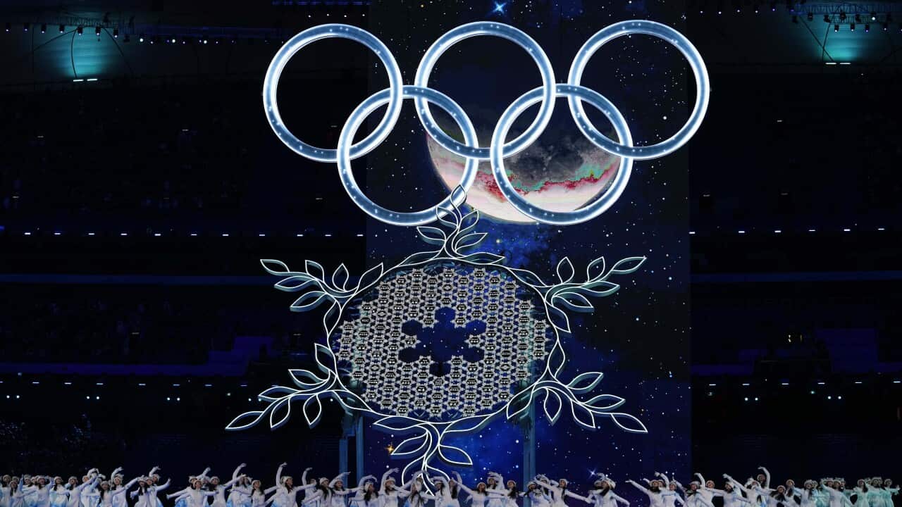A snowflake is displayed under the Olympic rings