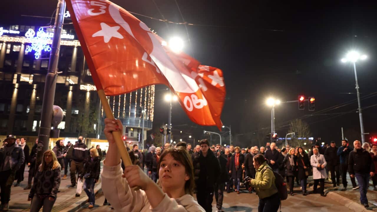 An opposition supporter waves a flag during a protest in Belgrade (AAP)