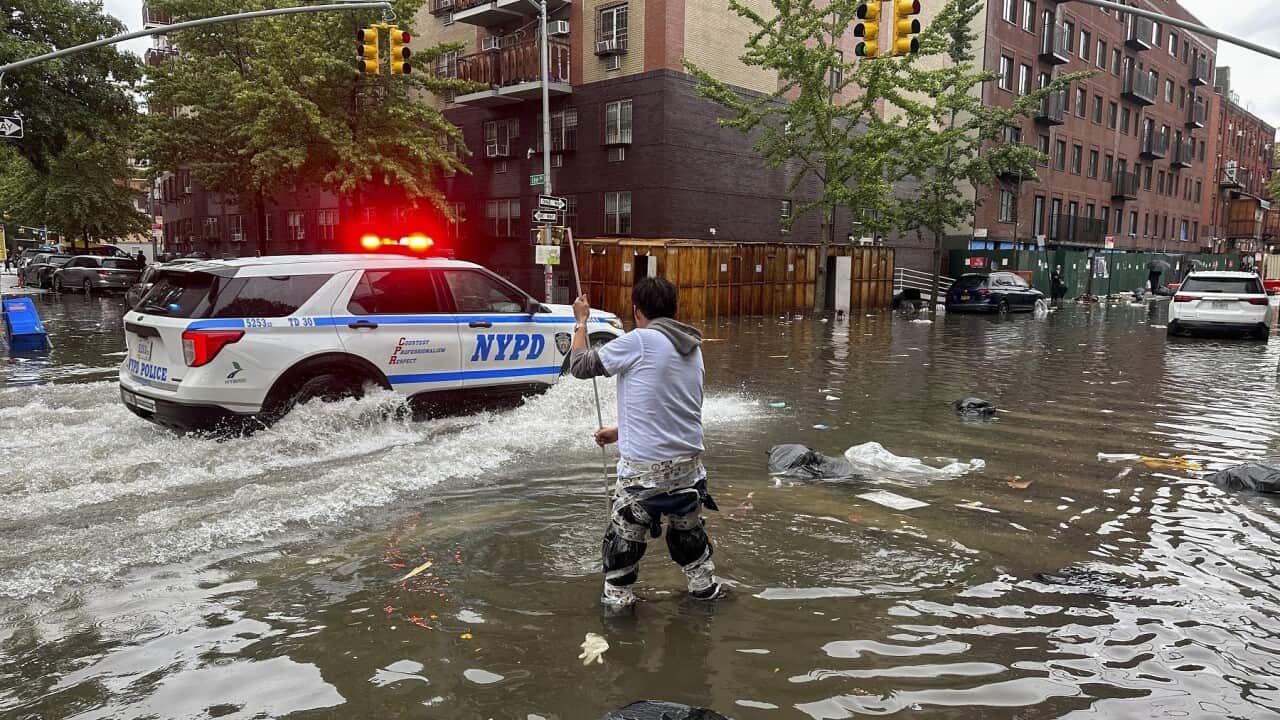 thumbnail_A man works to clear a drain in floodwaters in the Brooklyn borough of New York (AAP).jpg