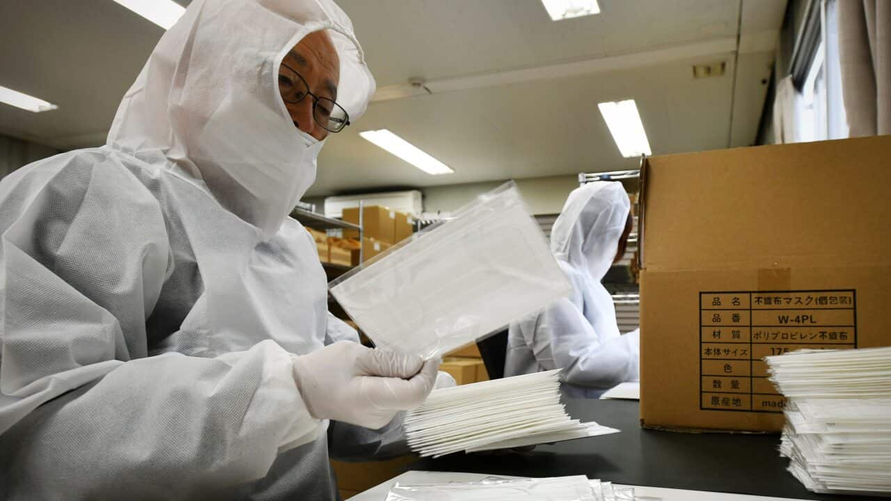 Employees from a mask company inspect products
