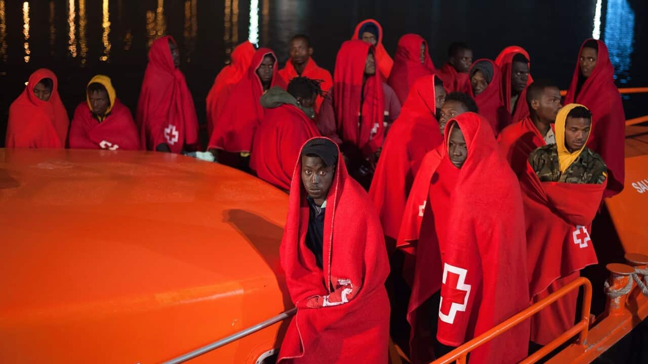 Migrants wrapped in blankets aboard a rescue boat after arriving at Malaga in Spain
