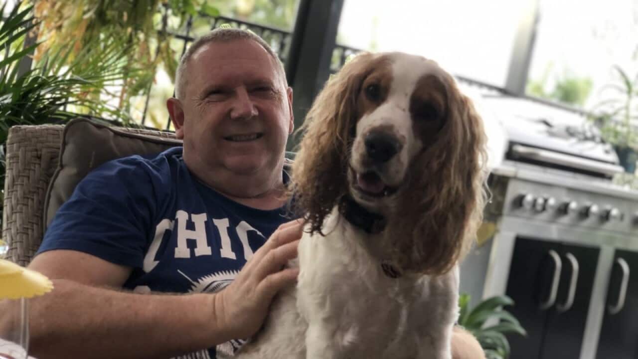 Paul sitting on a chair with a dog on his lap.