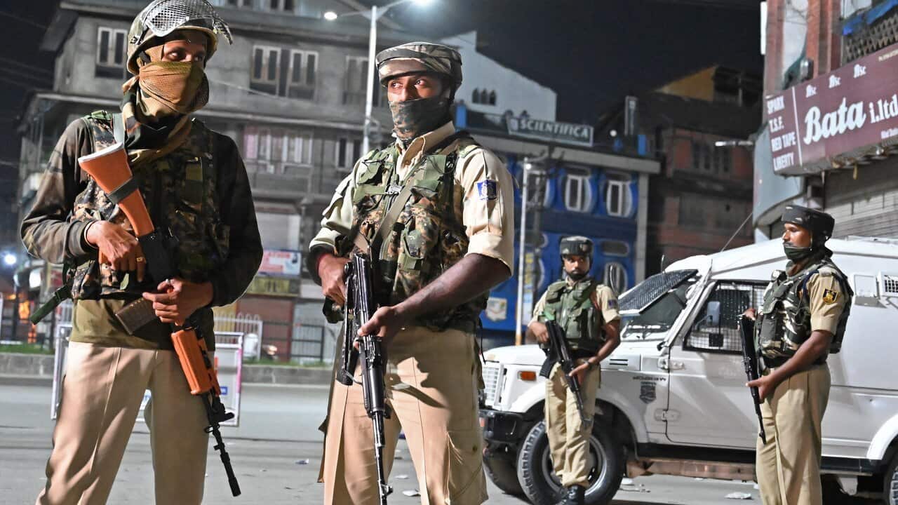 Indian paramilitary troopers stand guard at a roadblock at Maisuma locality in Srinagar.