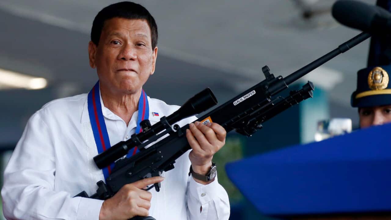 Philippine President Rodrigo Duterte holds an Israeli-made Galil rifle in suburban Quezon city northeast of Manila, Philippines. 