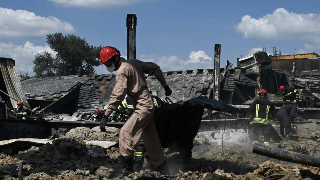 Ukrainian firefighters remove rubble from the site of an airstrike in Kremenchuk in search of victims on June 28th, 2022.