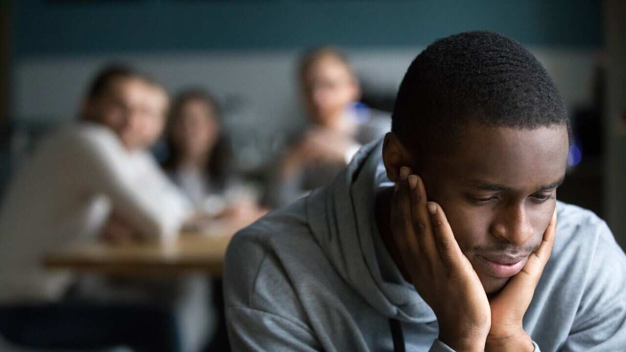 Black guy sit alone in cafe suffering from racial discrimination