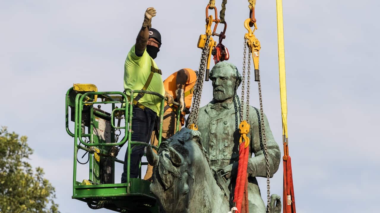 Workers remove the statue of Confederate General Robert E. Lee in Market Street Park in Charlottesville, Virginia, USA, 10 July 2021