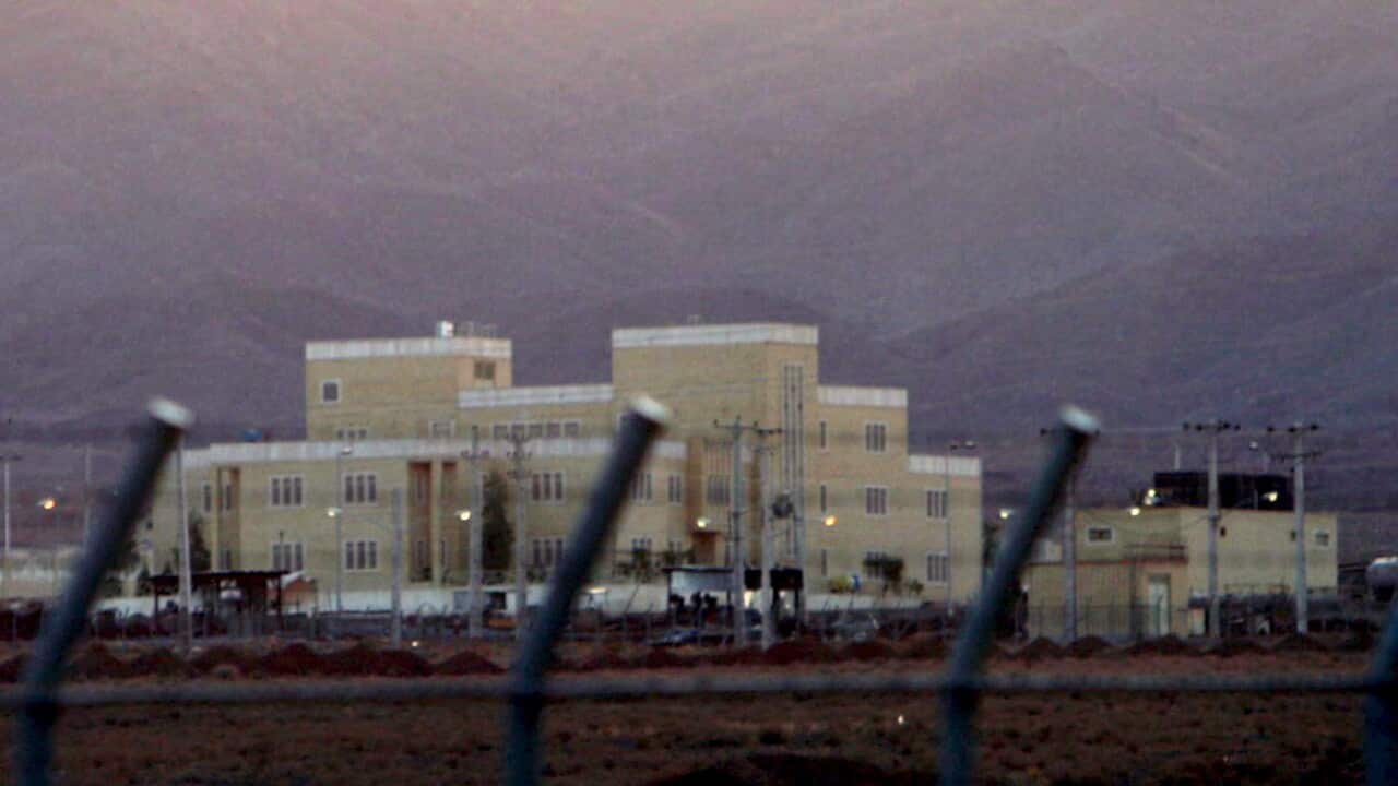 A nuclear facility with a mountain range rising behind it.