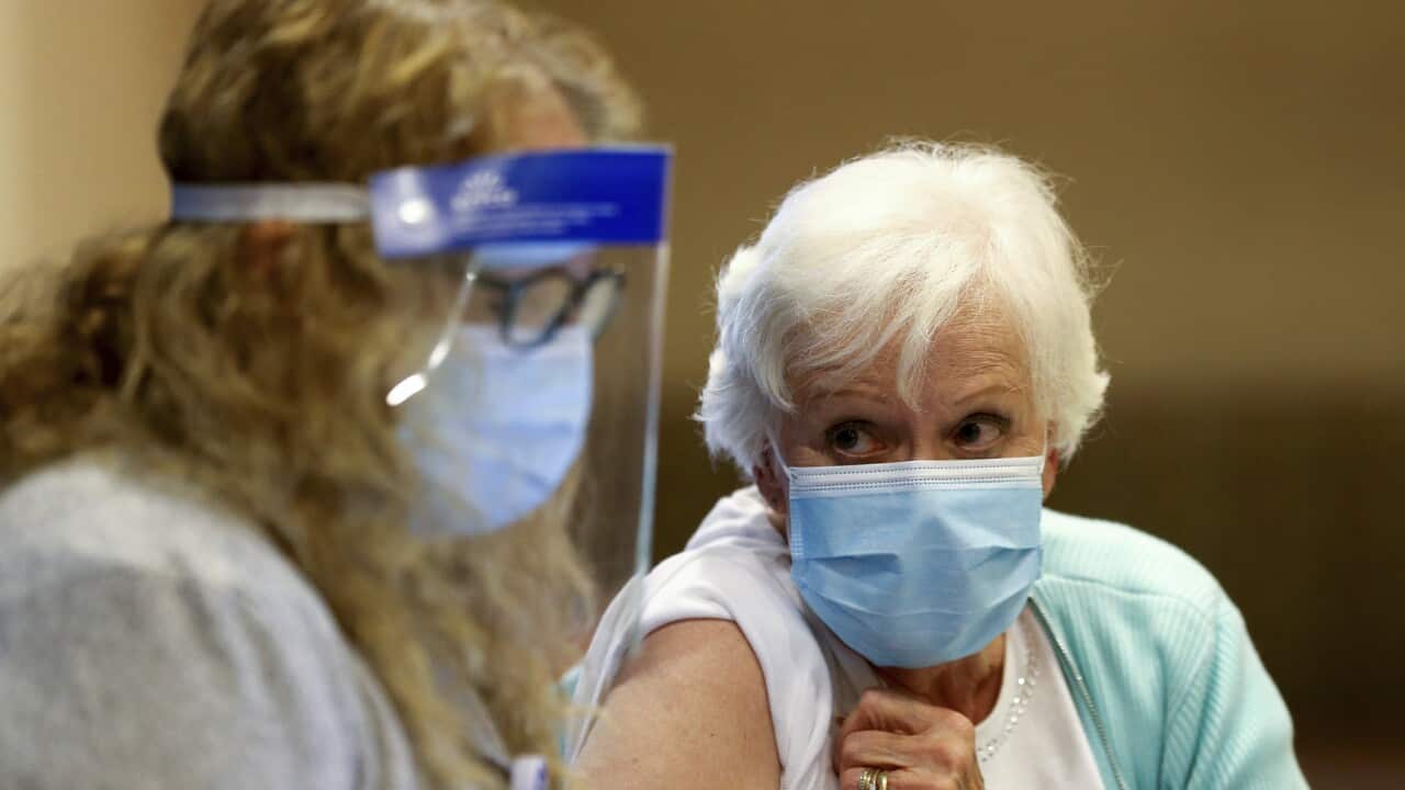 A woman receives her first dose of the COVID-19 vaccine