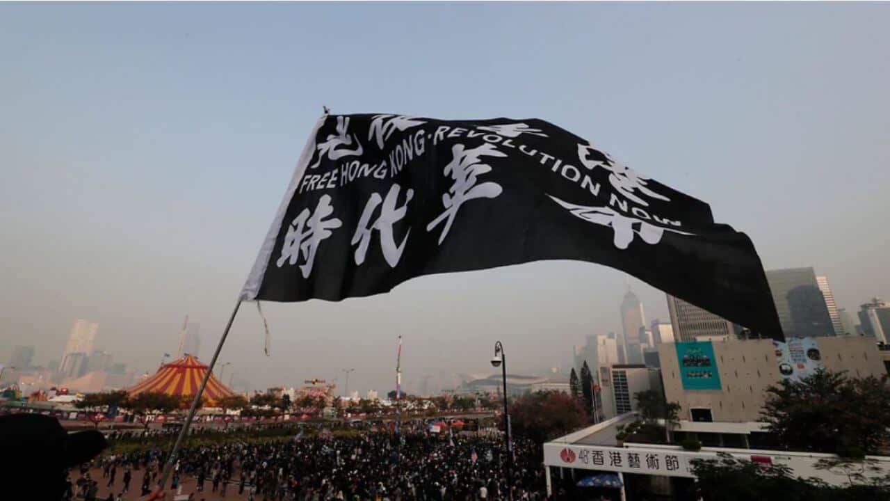 A man waves a flag as people gather during a rally to show support for Uighurs and their fight for human rights in Hong Kong.